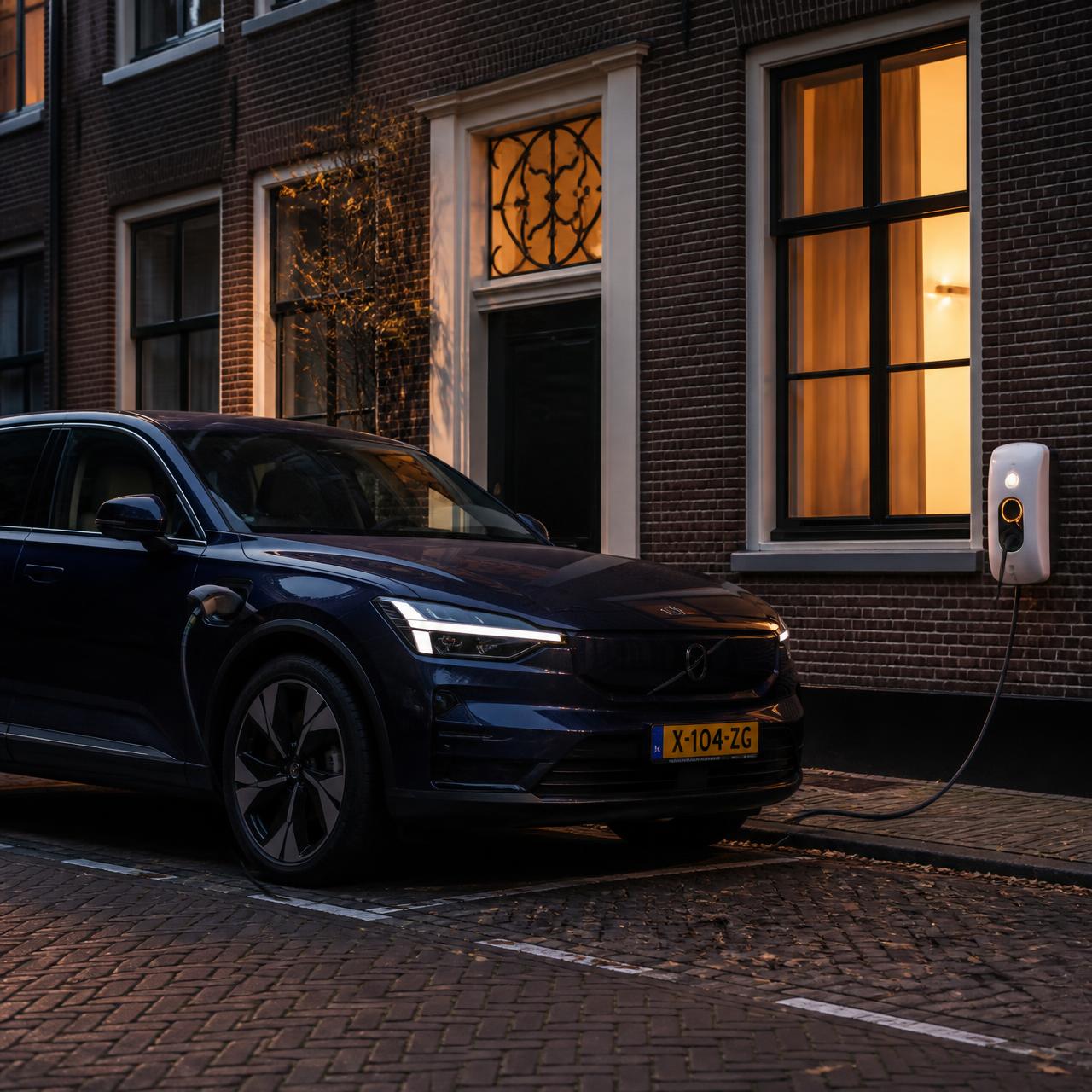 Donkerblauwe elektrische SUV die 's avonds oplaadt aan een witte wandlader tegen een Nederlandse bakstenen gevel